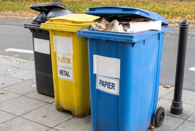 Siyah, mavi, sarı, yeşil çöp geri dönüşüm kutuları. Atıkları ayır, çevre kavramını koru. Atıkları ayır, çöpleri ayır. Kağıt, cam, plastik renkli çöp tenekeleri.