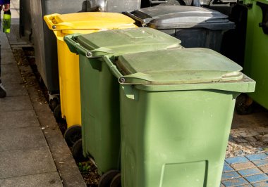 Siyah, mavi, sarı, yeşil çöp geri dönüşüm kutuları. Atıkları ayır, çevre kavramını koru. Atıkları ayır, çöpleri ayır. Kağıt, cam, plastik renkli çöp tenekeleri.