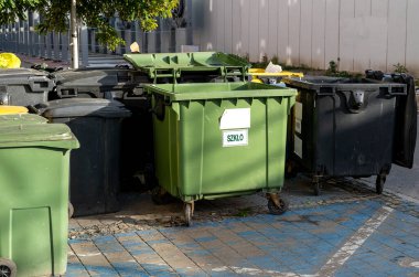 Siyah, mavi, sarı, yeşil çöp geri dönüşüm kutuları. Atıkları ayır, çevre kavramını koru. Atıkları ayır, çöpleri ayır. Kağıt, cam, plastik renkli çöp tenekeleri.