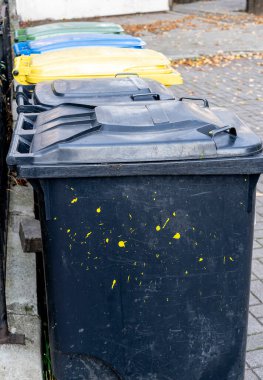 Siyah, mavi, sarı, yeşil çöp geri dönüşüm kutuları. Atıkları ayır, çevre kavramını koru. Atıkları ayır, çöpleri ayır. Kağıt, cam, plastik renkli çöp tenekeleri.
