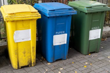 Siyah, mavi, sarı, yeşil çöp geri dönüşüm kutuları. Atıkları ayır, çevre kavramını koru. Atıkları ayır, çöpleri ayır. Kağıt, cam, plastik renkli çöp tenekeleri.