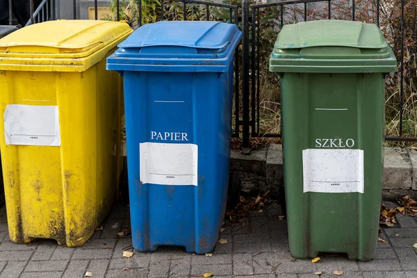 stock image Black, blue, yellow, green garbage recycling bins on street in city. Separate waste, preserve the environment concept. Segregate waste, sorting garbage. Colored trash cans with paper, glass, plastic