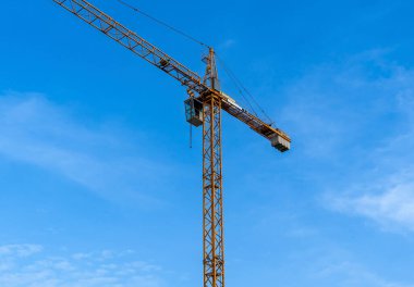 Mavi gökyüzüne karşı vinçleri olan bir inşaat alanı. Endüstriyel geçmiş. Modern gökdelenler. Tamamlanmamış yapı