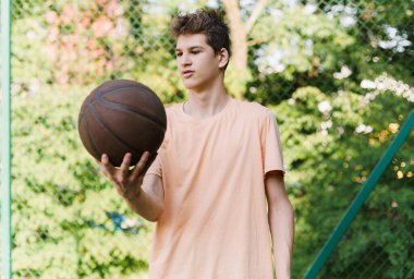 Stadyumda koşan bir genç. Sahada top oynayan kırmızı tişörtlü hoş bir genç kız. Spor, hobi, erkekler için aktif yaşam tarzı