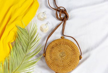 Straw hat and yellow summer dress on the white background. Spring, summer collection of women's clothing, accessories. Casual outfit
