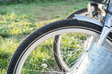 Bisiklet tekerleği. Yaklaş. Parktaki park yerinde sıra sıra bisikletler var. Yaz, bahar aktiviteleri. Yeni yaşam tarzı için bisikletler
