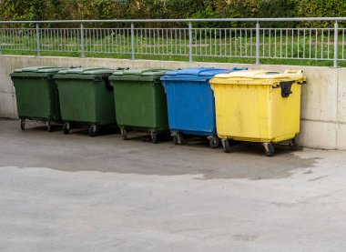 Siyah, mavi, sarı, yeşil çöp geri dönüşüm kutuları. Atıkları ayır, çevre kavramını koru. Atıkları ayır, çöpleri ayır. Kağıt, cam, plastik renkli çöp tenekeleri.
