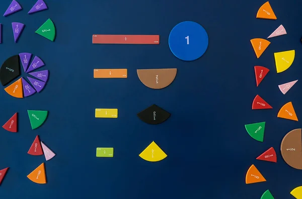 Math fractions on blue background. Interesting math for kids. Education, back to school concept. Geometry and mathematics materials. Close up