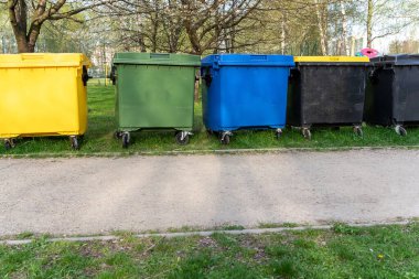 Siyah, mavi, sarı, yeşil çöp geri dönüşüm kutuları. Atık ayıklama, çevre geri dönüşümü kavramı. Atıkları ayır, çöpleri ayır. Kağıt, cam, plastik renkli çöp tenekeleri.
