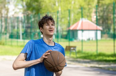 Sahada basketbol oynayan bir çocuk. Stadyumda koşan bir genç. Spor, hobi, erkekler için aktif yaşam tarzı