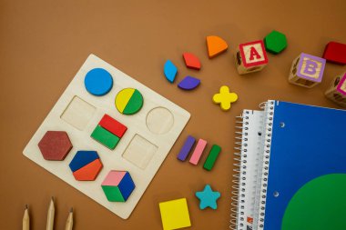 Kesirler, cetveller, kalemler, kahverengi arka planda not defteri. Matematik ve okul için malzeme seti. Okula dönüş, eğlenceli eğitim konsepti.