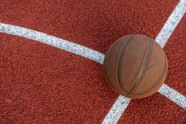 Basketbol topu yere düştü. Kırmızı sahada yakın çekim topu. Sokakta ya da kapalı sahada basketbol. İnsansız spor malzemeleri. Minimalizm. Şablon, spor arka planı