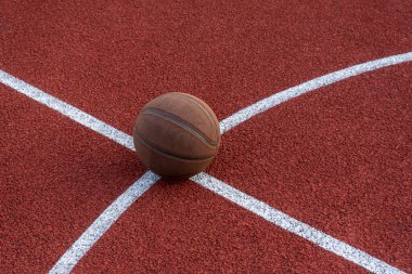 Basketbol topu yere düştü. Kırmızı sahada yakın çekim topu. Sokakta ya da kapalı sahada basketbol. İnsansız spor malzemeleri. Minimalizm. Şablon, spor arka planı