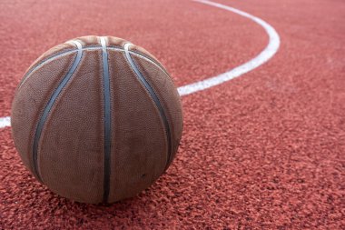 Basketbol topu yere düştü. Kırmızı sahada yakın çekim topu. Sokakta ya da kapalı sahada basketbol. İnsansız spor malzemeleri. Minimalizm. Şablon, spor arka planı