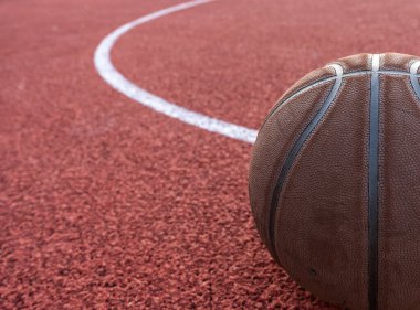 Basketbol topu yere düştü. Kırmızı sahada yakın çekim topu. Sokakta ya da kapalı sahada basketbol. İnsansız spor malzemeleri. Minimalizm. Şablon, spor arka planı