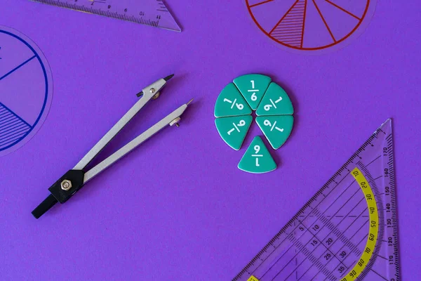 Fractions, rulers on violet background. Set of supplies for mathematics and for school. Back to school, fun education concept. Geometry background