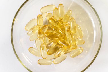 Beyaz arkaplandaki sarı kapsülleri kapat. Kapsüllerde Omega 3 yağı. Tıbbi, vitaminler, sağlık geçmişi