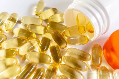 Beyaz arkaplandaki sarı kapsülleri kapat. Kapsüllerde Omega 3 yağı. Tıbbi, vitaminler, sağlık geçmişi