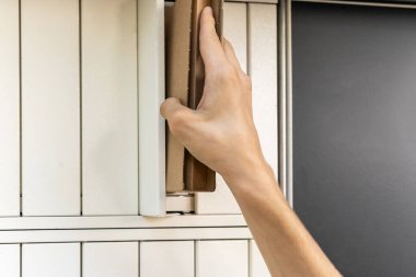 Posta terminalinin yanında elinde kutu olan bir adam. Paket teslimat makinesi. Elinde bir karton kutu tutan kişi. Posta ve posta servisi, online alışveriş, e-ticaret konsepti