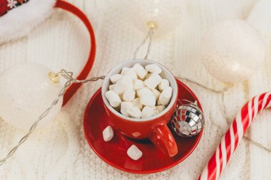 Bir fincan kahve, hediye kutusu, örgü süveter, bej arka planda ışık. Hygge tarzı, kış konsepti. Rahat ev masası. Yeni yıl ve Noel kutlaması modeli. Noel sakin hayat