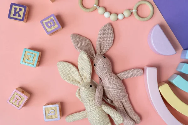 Bunny close up with toys, blocks on the pink background. activities for kids. preschool, kindergarten background