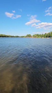Ilık güneş ışığı berrak suyla dolu sakin göle yansıyor. Bereketli yeşil ağaçlar kıyı boyunca uzanır. Huzurlu bir atmosfer yaratır. Rahatlamak ve keyif almak için mükemmel..