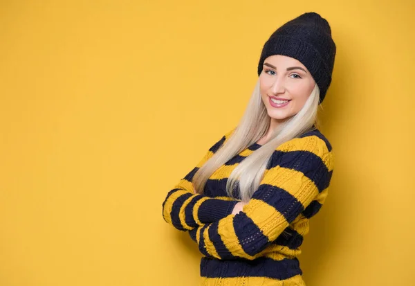 활기차게 모자와 스웨터를 배경에 고립된 여자가 카메라를 봅니다 스튜디오 — 스톡 사진