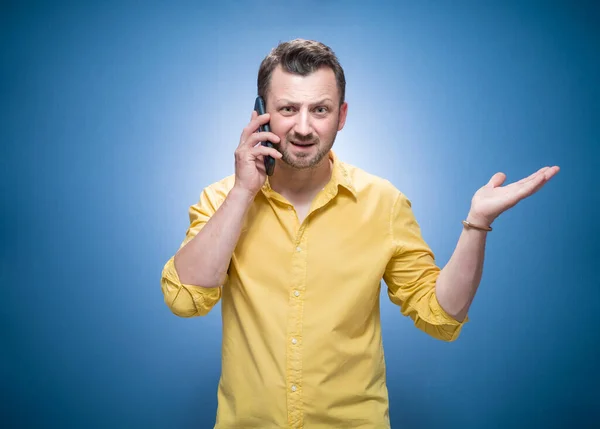 남자는 전화의 문자나 그림을 셔츠를 보여준다 스튜디오 — 스톡 사진