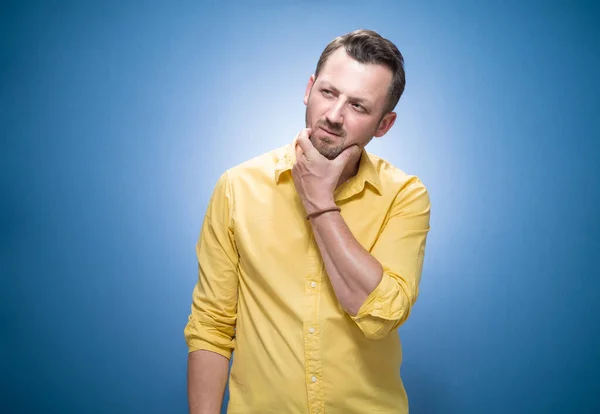 Pensive Mladý Muž Pocit Pochybnosti Modrém Pozadí Šaty Žluté Košili — Stock fotografie