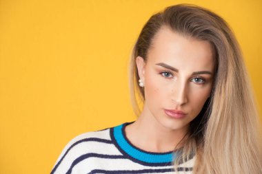 Sarı arka planda izole edilmiş, güzel sarışın kızın yakından çekilmiş yüzü. Genç ve güzel bir kadının vesikalığı. Stüdyo çekimi
