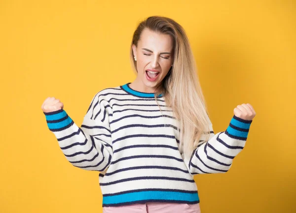 Aufgeregte Junge Frau Mit Geballten Fäusten Vereinzelt Auf Gelbem Hintergrund — Stockfoto