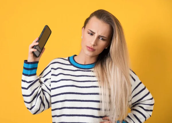 Genervtes Mädchen Telefon Isoliert Auf Gelbem Hintergrund Nervige Frauengespräche Belästigung lizenzfreie Stockbilder