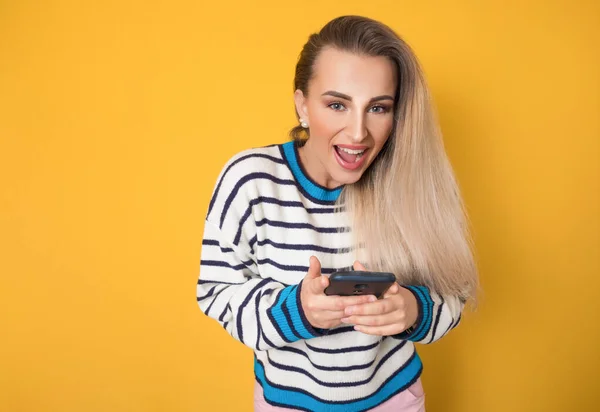 Überraschte Frau Mit Telefon Isoliert Auf Gelbem Hintergrund Trendiges Mädchen lizenzfreie Stockbilder