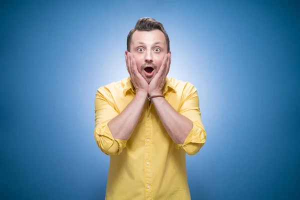 Halblange Begeisterte Junge Mann Vor Blauem Hintergrund Kleider Gelbem Hemd — Stockfoto