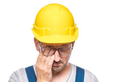 Yorgun inşaat işçisi gözlerini ovuşturuyor, beyaz arka planda izole edilmiş. Gözleri kapalı bitkin bir tamirci. Orta yaşlı inşaat işçisi yüzünü kapatıyor. Uykulu ifade. Stüdyo çekimi