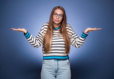 Çözüm. Kolları açık genç bir kadın seçmenize izin veriyor, mavi arka planda soyutlanmış bir şekilde. Stüdyo çekimi