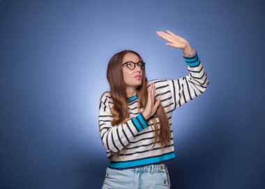 Ayrımcılık - Şiddet. Genç bir kadın patronuna saygı duyuyor ve kendini savunuyor, mavi arka planda soyutlanmış. Kurban konsepti. Stüdyo çekimi