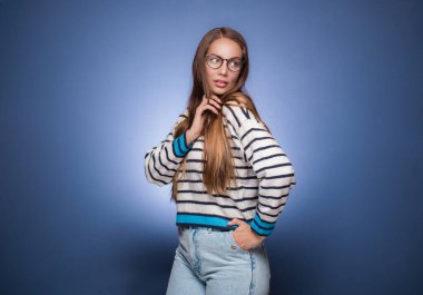 Güzel bir kadın poz veriyor, mavi arka planda izole edilmiş. Taraf tutan güzel bir kız. Uzayı kopyala Stüdyo çekimi