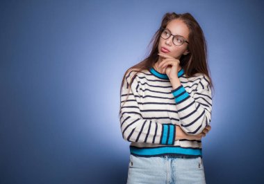 Düşünceli genç bir kadın kendini şüpheli hissediyor. Mavi arka planda izole edilmiş mesajlar için yer kopyalıyor. Kız düşüncesi. Uzayı kopyala Stüdyo çekimi