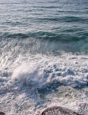 Köpüklü yüzeyi ve dalgaları olan deniz suyu. Sahildeki yeşil ve mavi akan suyun yakın çekim görüntüsü. Atlantik Okyanusu Duvar Kağıdı