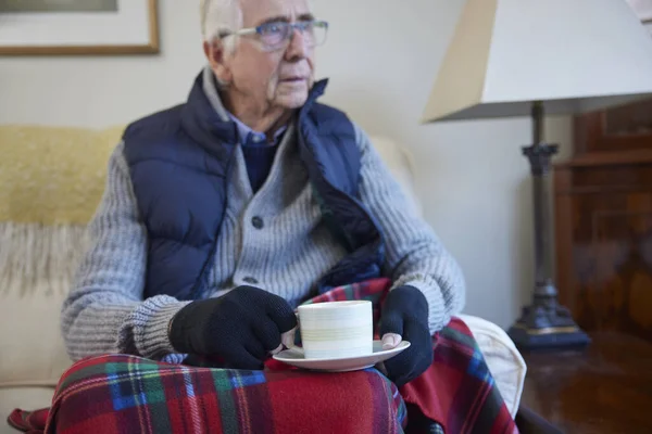 Starszy Mężczyzna Dodatkowych Ubraniach Gorącym Napojem Próbuje Utrzymać Ciepło Domu — Zdjęcie stockowe