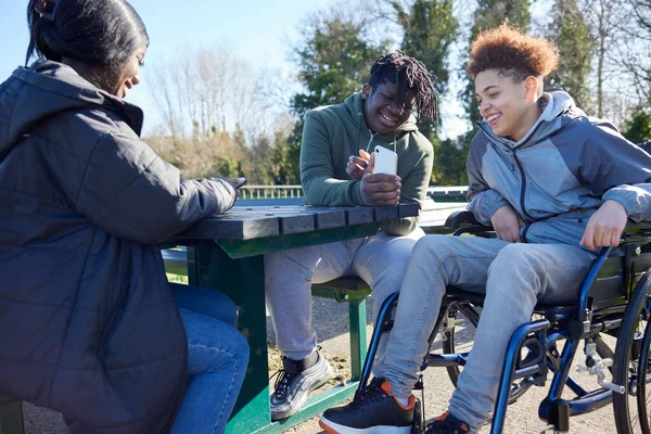 Teenagermädchen Rollstuhl Mit Freunden Schaut Sich Soziale Medien Auf Mobiltelefonen — Stockfoto
