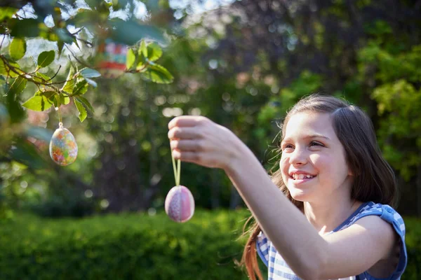 Mädchen Hängt Selbstgemachte Osterdekorationen Freien Baum Garten lizenzfreie Stockfotos
