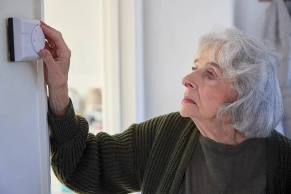 Besorgte Seniorin Schaltet Energiekrise Heizungsthermostat Hause — Stockfoto
