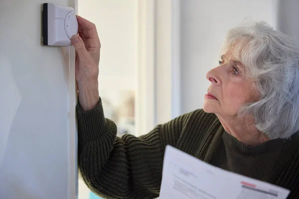 Orolig Äldre Kvinna Med Bill Vrida Ner Centralvärme Termostat Hemma — Stockfoto