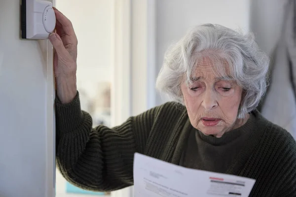 Ανήσυχη Ηλικιωμένη Γυναίκα Νομοσχέδιο Απορρίπτοντας Κεντρική Θέρμανση Θερμοστάτη Στο Σπίτι — Φωτογραφία Αρχείου