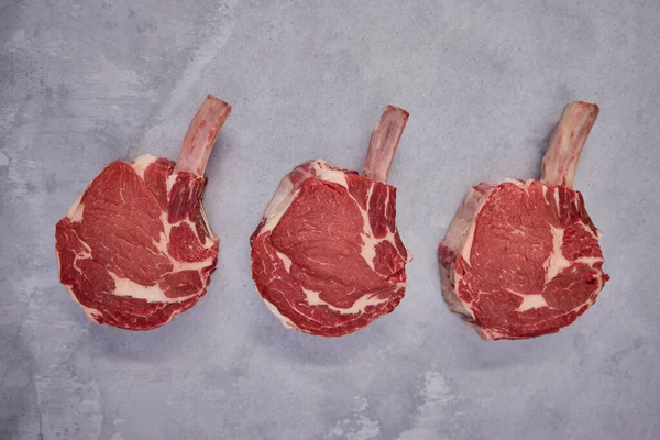 stock image Overhead Shot Of Tomahawk Beef Steaks On Background In Butcher's Shop Display