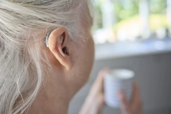 Close Senior Woman Wearing Ear Hearing Device Aid Hot Drink — Stock Photo, Image