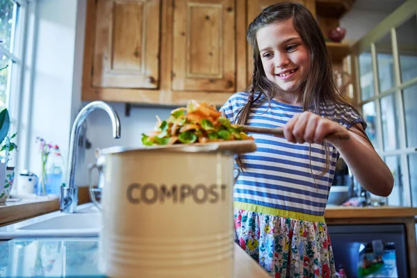 Mädchen Der Küche Macht Kompost Der Gemüsereste Den Papierkorb Schabt lizenzfreie Stockbilder