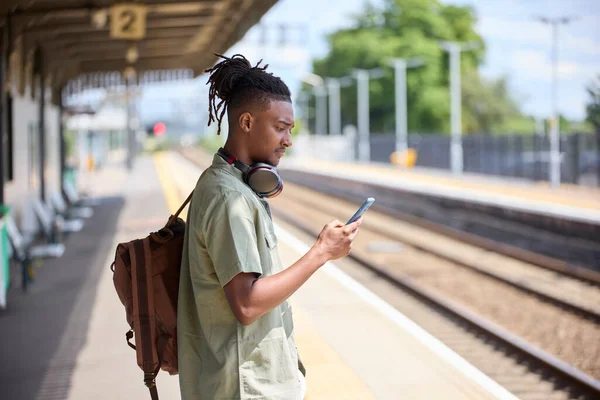 Молодий Чоловік Закликає Працювати Поїзді Стоїть Платформі Дивлячись Мобільний Телефон Стокова Картинка